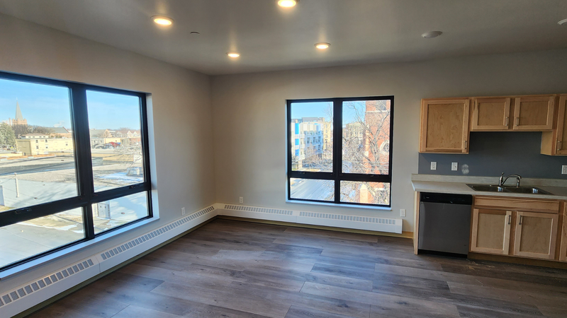 large living room area with large windows inside 2-bedroom apartment home.