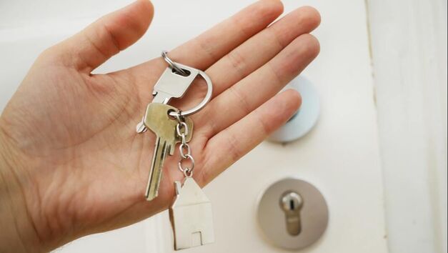 Photo of keys in hand to unlock door representing Management.